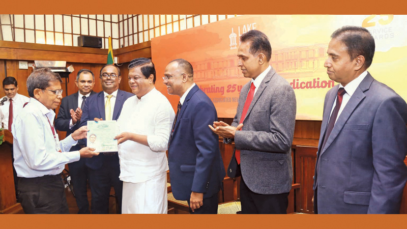 Sunday Observer journalist Benzie Roche who completed 51 years of uninterrupted service at Lake House being recognised with a special memoir by Transport, Highways and Mass Media Minister Dr. Bandula Gunawardana. Chairman Prof. Harendra Kariyawasam, Director Editorial Sisira Paranathanthri, Director Finance Dr. Sunil Jayantha Navaratne, Director Legal and Administration Janaka Ranatunga, Director Operations Manjula Makumbura and ANCL General Manager Sumith Kotalawala were present.